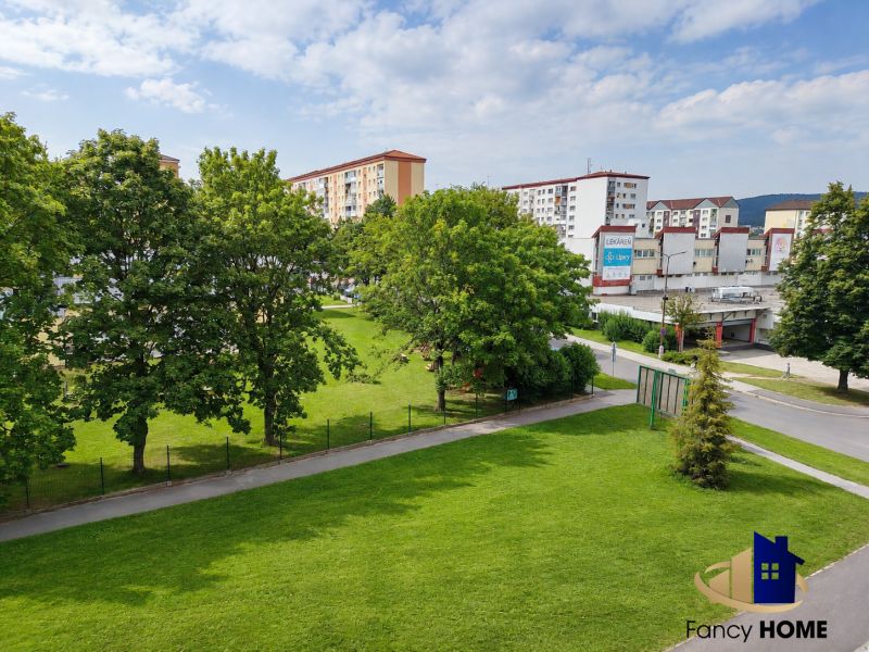 Zelený park obklopený panelákmi na ulici Tatranská v meste Stará Ľubovňa.