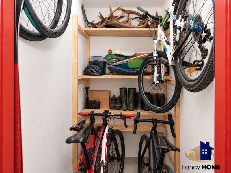 Úložný priestor s bicyklami, policami a športovým vybavením v 3-izbovom byte.